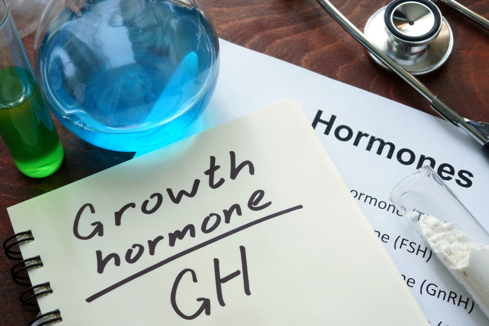 growth hormone written on notebook. Test tubes and hormones list.